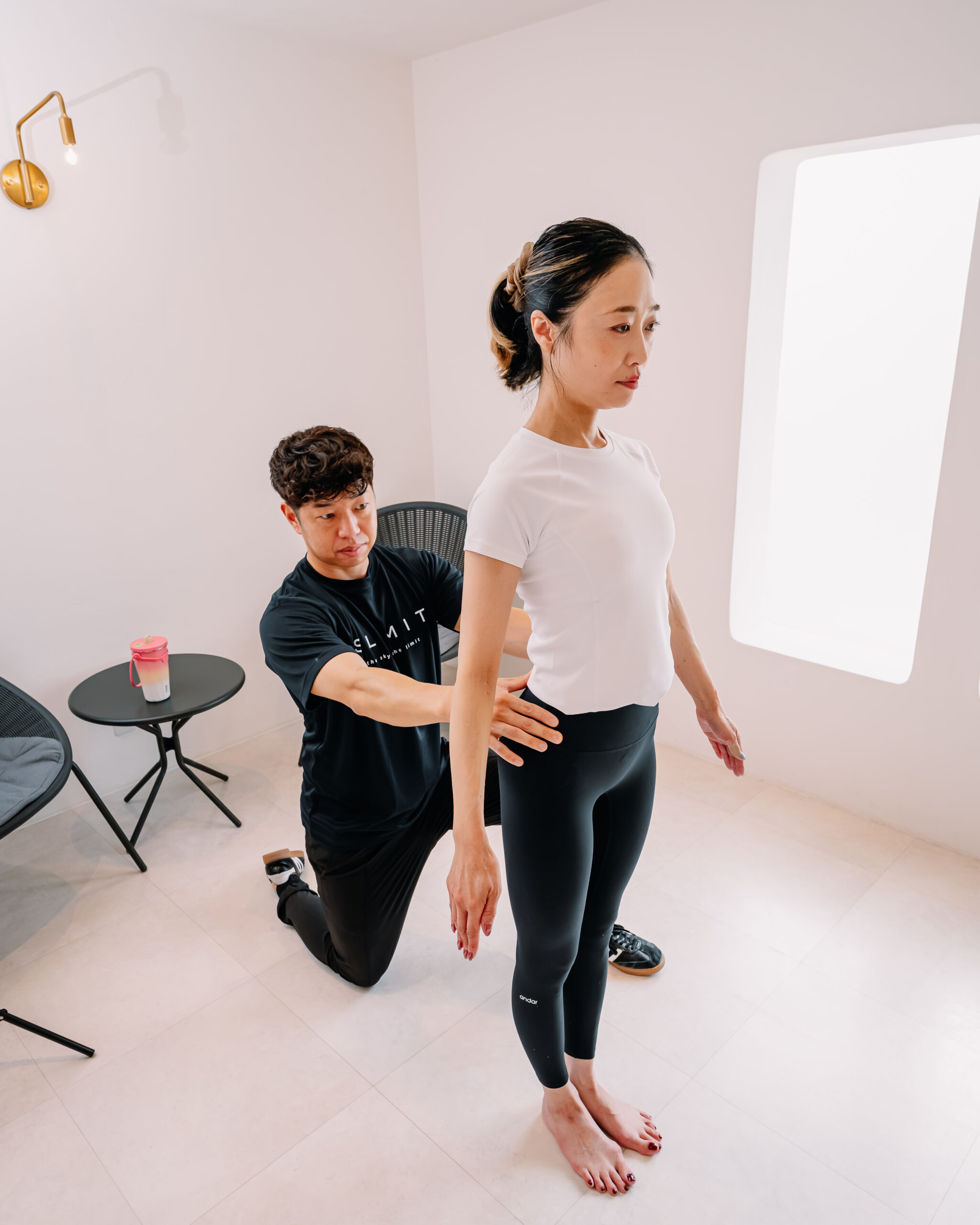 立ち姿勢から体の使い方を丁寧に評価するトレーナー