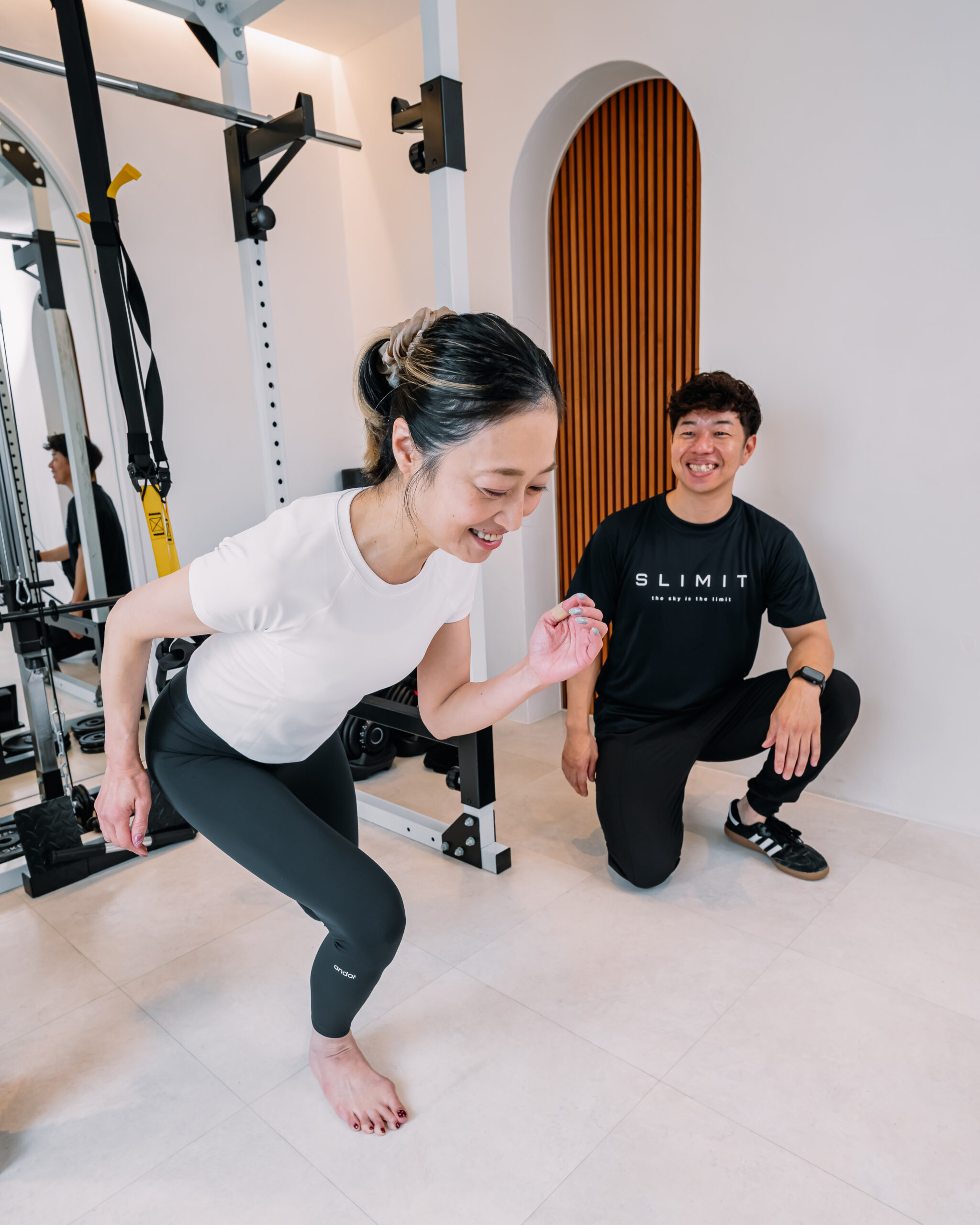 トレーナーと一緒に笑いながらトレーニングに取り組む様子